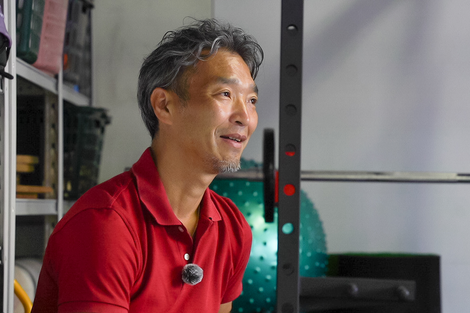 トレーニング機器の前で笑顔を見せる森脇幹人