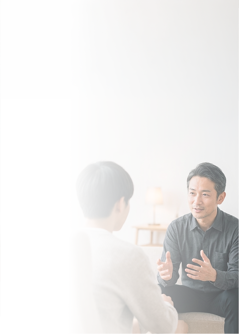 向かい合って話をするカウンセラーと相談者の男性