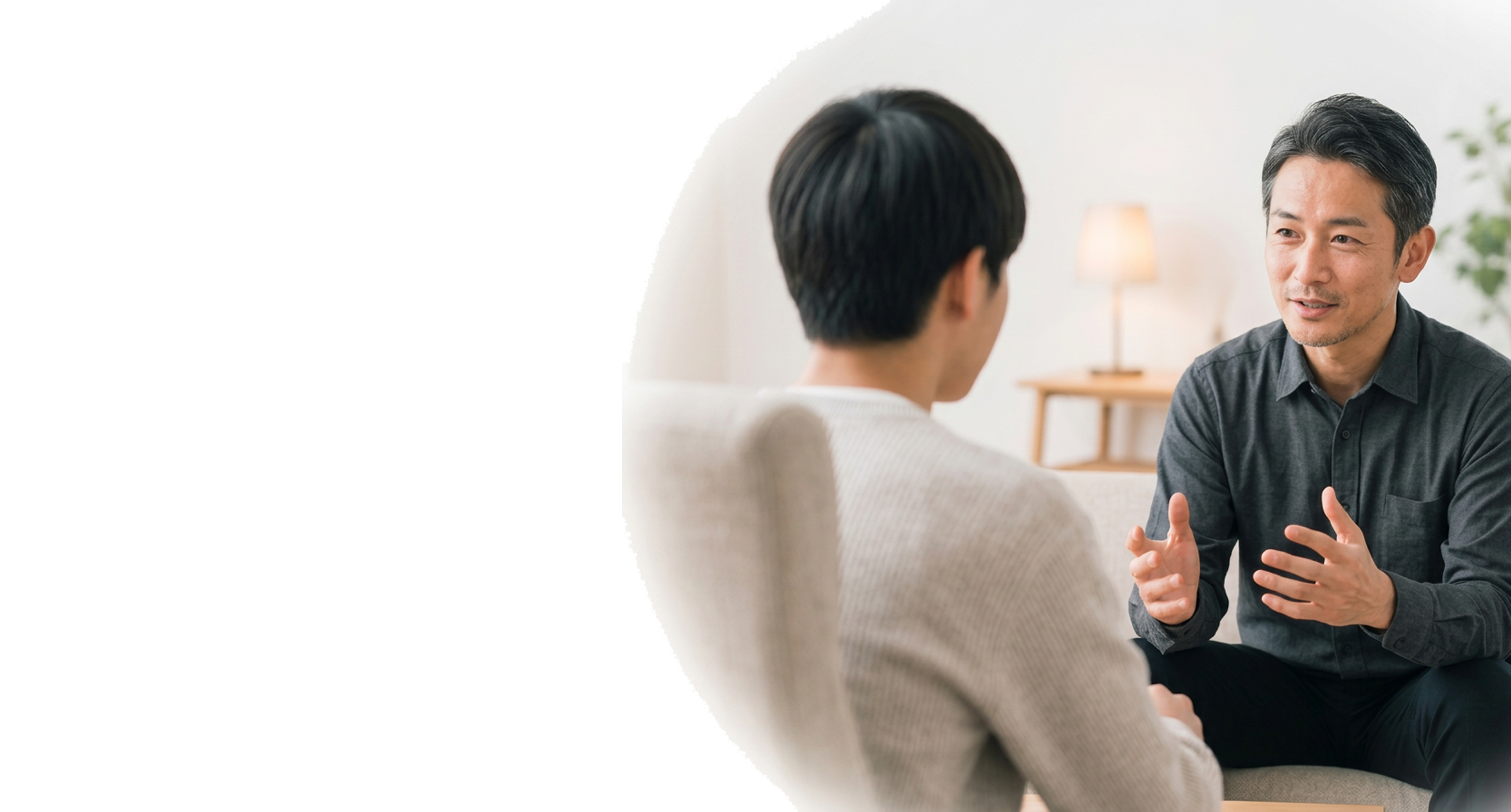 向かい合って話をするカウンセラーと相談者の男性