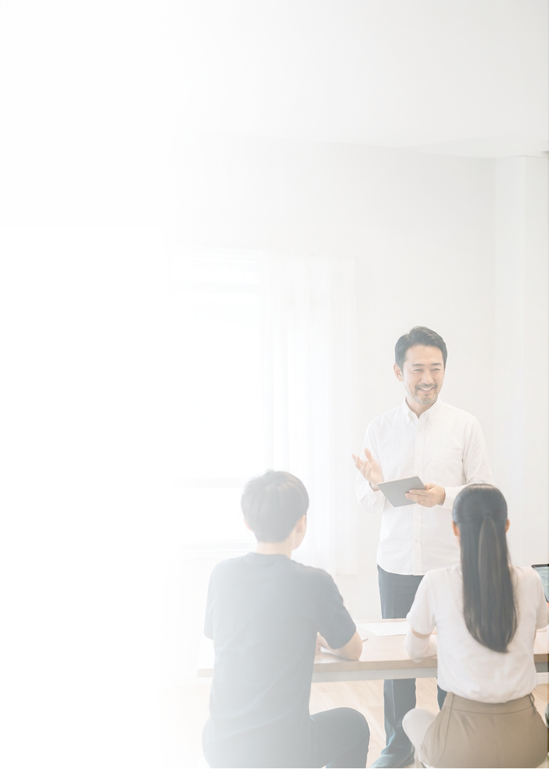 タブレットを片手に生徒たちへ説明する男性講師