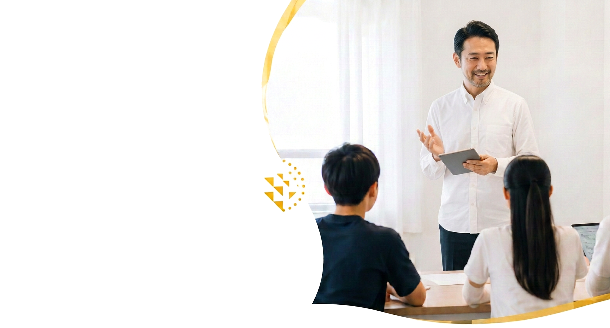 タブレットを片手に生徒たちへ説明する男性講師